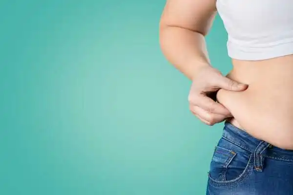 Image of woman pinching her love handles to show weight gain Edinburgh